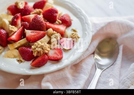 Frühstücksschale mit Müsli, Erdbeeren, Bananen und Milch Stockfoto