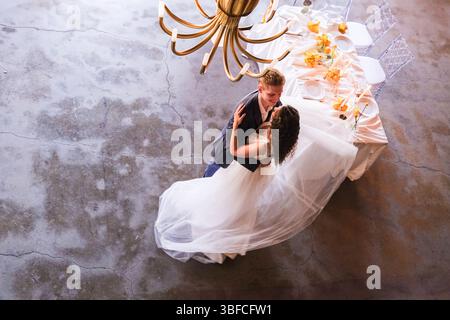 moskau, russland, 22.05.2025 Braut und Bräutigam tanzen vor einem Tisch mit Tellern und Tassen. Die Szene ist romantisch und feierlich Stockfoto