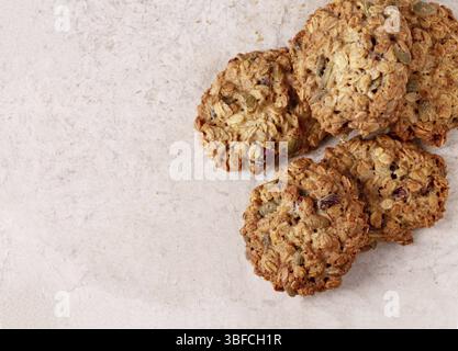Hausgemachte Haferflockenkekse mit Beeren und Samen auf Vintage-Papier, Platz für Text Stockfoto