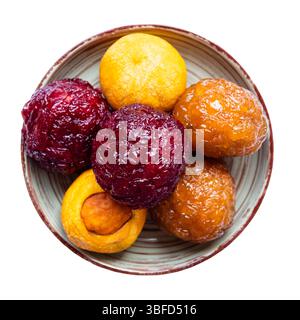 Blick von oben auf verschiedene armenische Alani-Süßigkeiten, hergestellt aus getrockneten Früchten und Nüssen mit Honig, auf Teller ausgeschnitten auf weißem Hintergrund Stockfoto