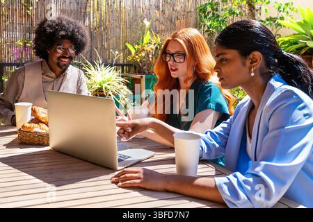 Multiethnische kleine Gruppe von Geschäftsleuten treffen sich in einem kooperierenden Firmenbüro - Junge Kollegen arbeiten zusammen in einem kreativen Stockfoto