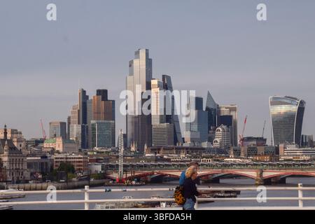 London, England, Großbritannien. 31. Mai 2025. Die Menschen laufen entlang der Waterloo Bridge vorbei an der Skyline der City of London, dem Finanzviertel der Hauptstadt. (Kreditbild: © Vuk Valcic/ZUMA Press Wire) NUR REDAKTIONELLE VERWENDUNG! Nicht für kommerzielle ZWECKE! Stockfoto