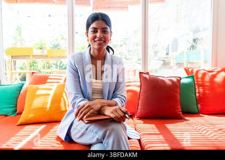 Schöne indische Geschäftsfrau, die in einem kooperierenden Firmenbüro arbeitet - Junge Frau, die Business-Freizeitkleidung trägt, arbeitet in einer kreativen Statur Stockfoto