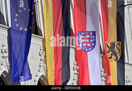 Weimar, Deutschland. 30. Mai 2025. Flaggen für Europa, Deutschland, Thüringen und Weimar fliegen vor dem historischen Rathaus von Weimar auf dem Marktplatz. Das permanente Fahnenfliegen auf öffentlichen Gebäuden wird zu einem Thema. Immer mehr Kreise in Thüringen diskutieren darüber, ob vor Schulen und Verwaltungsgebäuden ständig Fahnen fliegen sollen. Quelle: Martin Schutt/dpa/Alamy Live News Stockfoto
