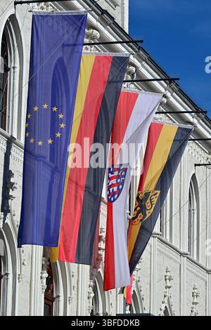 Weimar, Deutschland. 30. Mai 2025. Flaggen für Europa, Deutschland, Thüringen und Weimar fliegen vor dem historischen Rathaus von Weimar auf dem Marktplatz. Das permanente Fahnenfliegen auf öffentlichen Gebäuden wird zu einem Thema. Immer mehr Kreise in Thüringen diskutieren darüber, ob vor Schulen und Verwaltungsgebäuden ständig Fahnen fliegen sollen. Quelle: Martin Schutt/dpa/Alamy Live News Stockfoto