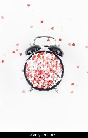 Valentinstag. Kreativurlaub Konzept von rot in Herzform süße Konfetti mit Wecker. Valentines Tag Draufsicht liebe Zusammensetzung auf whit Stockfoto
