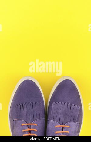 Flach von Wildleder Schuhe auf Bold gelbes Papier Hintergrund mit kopieren. Ansicht von oben von Frau casual Outfit. Trendy hipster look Top View Stockfoto