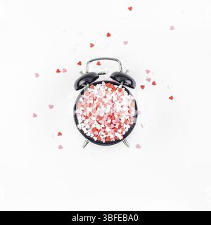 Valentinstag. Kreativurlaub Konzept von rot in Herzform süße Konfetti mit Wecker. Valentines Tag Draufsicht liebe Zusammensetzung auf whit Stockfoto