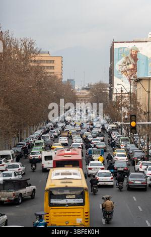 Teheran, Iran - 12. November 2023: Dichter Verkehr mit Bussen, Autos und Wandgemälden im Stadtzentrum Stockfoto