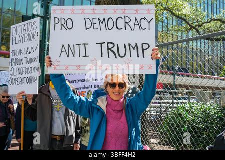 New Orleans, LA, USA - 17. Februar 2025: New Orleans, LA, USA - 17. Februar 2025: Nahaufnahme des Marschers mit dem Schild „Pro Democracy, Anti Trump“ und einer Menschenmenge, die in der Innenstadt von New Orleans marschiert, um gegen das I.C.E. Büro in der Poydras Street zu protestieren Stockfoto