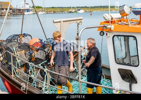 Wells, Norfolk, Großbritannien – Mai 31 2025. Fischer auf einem kommerziellen Fischerboot in Wells Harbour, North Norfolk Coast Stockfoto