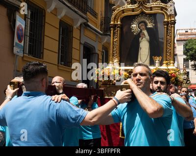 Madrid, Spanien. Juni 2025. Mitglieder der Bruderschaft, die den Wagen während der außerordentlichen Prozession der Muttergottes von der Einsamkeit während des 25. Jahrestages der Krönung der Jungfrau der Taube von Madrid tragen. © Valentin Sama-Rojo/Alamy Live News. Stockfoto