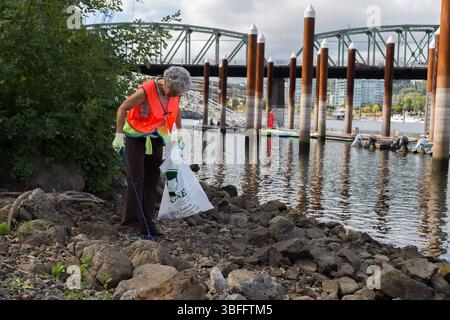 Portland, Oregon - 17. August 2017: Ein Freiwilliger sammelt Müll entlang des Ufers auf und hilft, die Umwelt sauber und gesund zu halten. Stockfoto