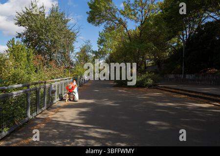 Portland, Oregon – 17. August 2017: Eine Person in einem orangefarbenen Hemd sammelt Müll auf einem Weg auf, um die Gegend sauber zu halten. Stockfoto