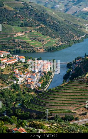 Das Dorf Pinhão liegt am Fluss Tua, der in den Fluss Douro mündet, umgeben von terrassenförmig angelegten Weinbergen im Douro-Tal Stockfoto