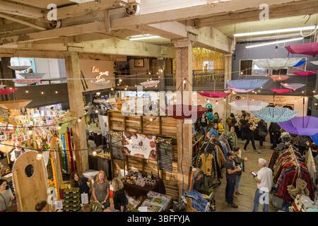 Portland Night Market, Portland, Oregon - 29. September 2017: Ein belebter Indoor Market mit Händlern und Käufern unter hängenden Regenschirmen und Schnur Stockfoto