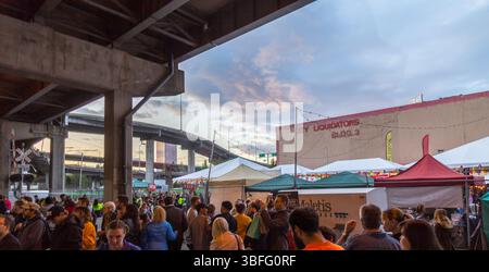 Portland Night Market, Portland, Oregon – 30. September 2017: Menschenmassen versammeln sich an den Verkaufsständen unter der Überführung in der Abenddämmerung. Stockfoto