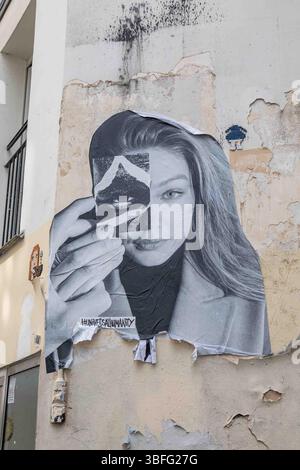 Gestanztes Posterporträt von Gigi Hadid von Thomas Iser, Teil des Projekts Universal Humanity, an der Gebäudemauer im Pariser Stadtteil Marais Stockfoto