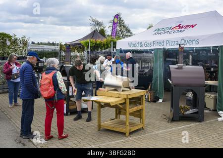 Ausstellungsstand für Pizzaöfen (Kunden stöbern, Verkäufer erklären dies) - Harrogate Spring Flower Show 2025, Yorkshire England, Großbritannien. Stockfoto