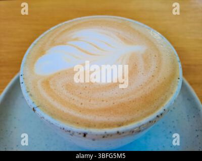 Kaffee, Cappuccino mit Blick von oben mit Latte Art auf dem Tisch oder Hintergrund im Café. Nahaufnahme. Wunderschönes Latte Art Konzept. Hintergrund der café-Pause. italia Stockfoto