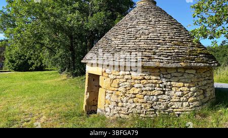 Eine traditionelle kleine, runde Steinhütte, oder Boire, mit einem konischen Dach, das traditionelle Handwerkskunst in der Region Perigord Noir in Frankreich zeigt Stockfoto