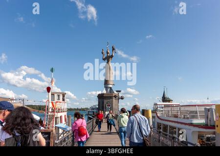 KONSTANZ, DEUTSCHLAND - 24. SEPTEMBER 2023: Eine geschäftige Szene am Pier in Konstanz, die zur berühmten Imperia-Statue unter einem klaren, b Stockfoto