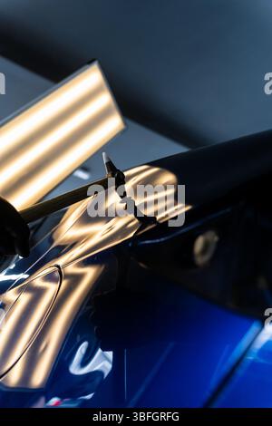 Der Techniker verwendet PDR-Werkzeuge, um Dellen von der Motorhaube während der lacklosen Reparatur der Dellen zu entfernen. Bei der lacklosen Dellen-Reparatur bei PDR werden Dellen unter hellen Stellen angestoßen Stockfoto