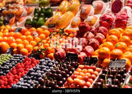 Fresh fruits displayed at a vibrant market stall attracting shoppers and visitors Stockfoto