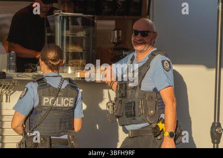 Kununurra Australien - 11. Mai 2025; zwei uniformierte Polizeiverbrecher, ein Mann und eine Frau am Coffee Cart. Stockfoto