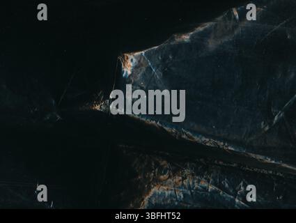 Distress-Folie. Gebrochene Textur. Staubkratzer beschädigter Bildschirm gerissener Effekt auf dunklem schwarzblauem, ungleichmäßigem abstraktem Retro-Hintergrund. Stockfoto