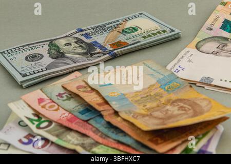 Auf einer Tabelle werden verschiedene Banknoten aus verschiedenen Ländern angezeigt, die den Kontrast zwischen farbenfrohen Fremdwährungen und knackigem US-Dollar hervorheben Stockfoto