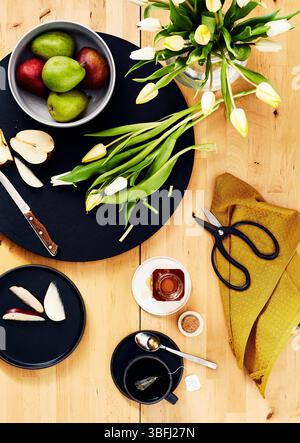 Frische Birnen, Tee, Tulpen und Honig auf Holzoberfläche Stockfoto