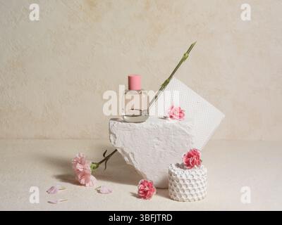 Elegante Einrichtung mit einer Glaskosmetikflasche und rosafarbenen Blumen Stockfoto