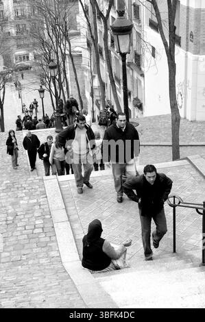 Paris 2006 Menschen gehen an einer bettelnden Frau auf der Treppe der Rue Foyatier in Montmartre, Paris, vorbei. Stockfoto