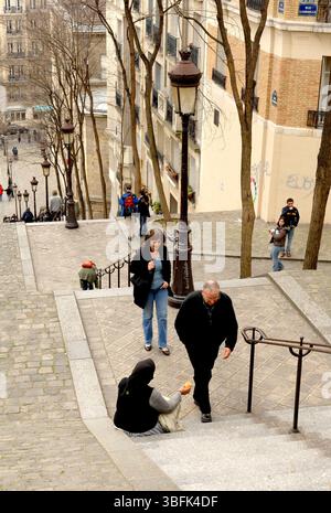 Paris 2006 Menschen gehen an einer bettelnden Frau auf der Treppe der Rue Foyatier in Montmartre, Paris, vorbei. Stockfoto