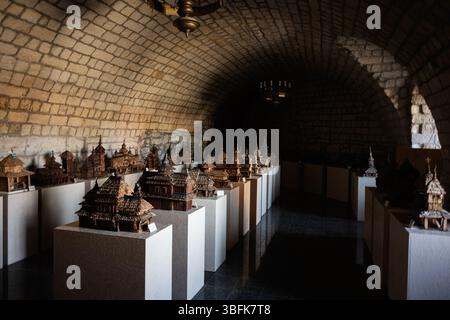 Zbarazh, Ukraine - 30. Mai 2025: Ausstellung von handgefertigten Holzkirchenmodellen in einem gewölbten Steininneren Stockfoto