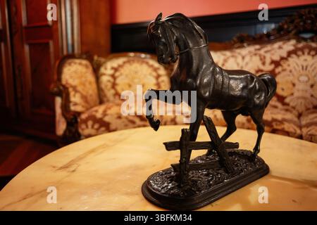 Eine detaillierte Pferdestatue, die auf einem Tisch in einem opulenten traditionellen Wohnzimmer ausgestellt wird Stockfoto