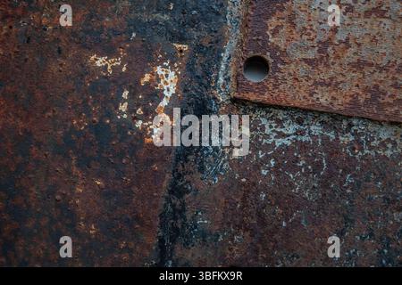 Rostige korrodierte Metalloberfläche auf verlassener Werftstruktur, die Verfall- und Texturdetails zeigt Stockfoto