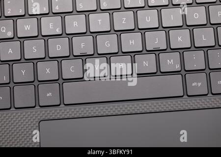 Nahaufnahme der sauberen Laptop-Tastatur mit Teil der Leertaste und des Touchpads, die Studiobeleuchtung hebt das schlanke graue Design in scharfem Fokus hervor Stockfoto
