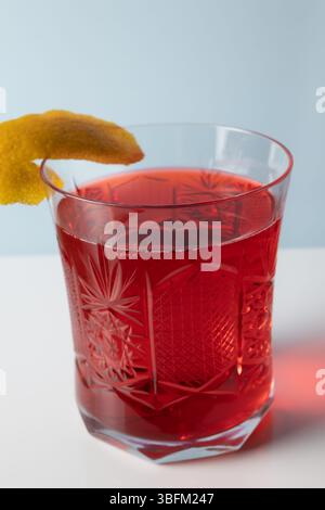 negroni Cocktail mit Zitronenschalen garniert in Kristallglas Stockfoto