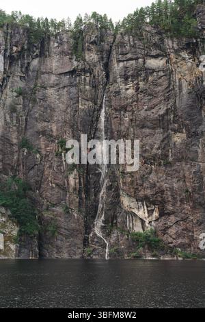 Hoher schmaler Wasserfall auf steiler Fjordklippe in der Nähe von Bergen, Norwegen Stockfoto