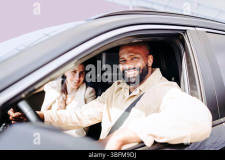 Porträt eines lächelnden bärtigen Mannes, der mit einer Frau auf dem Fahrersitz sitzt Stockfoto