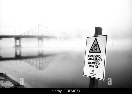 Aus der ätherischen Umarmung des Nebels erhebt sich eine einsame Brücke. Stockfoto