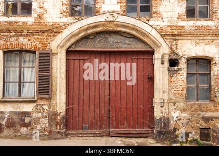 Montreuil Sur Mer, Frankreich. Große Holztüren im Torbogen in einem sehr alten Gebäude. Stockfoto