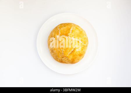 Rundes weißes Brot auf einer weißen Platte mit weißem Hintergrund. Stockfoto
