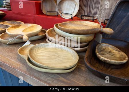 Sammlung von handgefertigten Holztellern, Schüsseln und Serviergeschirr, ausgestellt auf Holztisch auf einem Kunsthandwerkermarkt, natürliche Holzkörner, Qualität und c Stockfoto