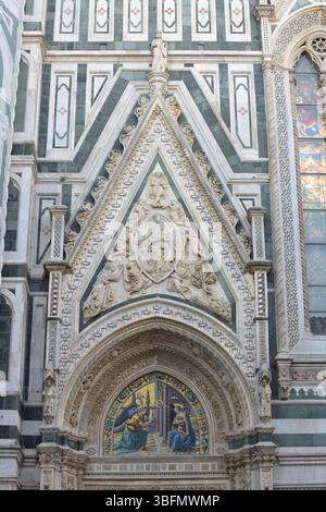 Portal der Kathedrale von Florenz mit Marmortympanon und Mosaik der Verkündigung der Brüder Ghirlandaio im neogotischen Stil. Stockfoto
