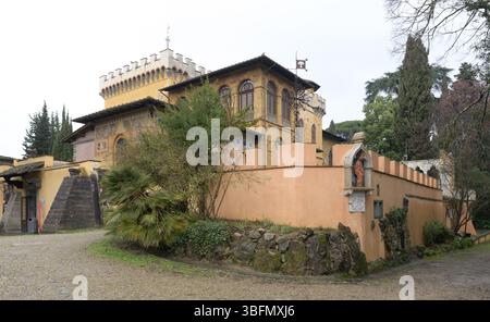 Blick von außen auf die Villa Stibbert, eine vielseitige Villa aus dem 19. Jahrhundert mit neogotischen Elementen, umgeben von Garten und Steinmauer, Florenz, Italien. Stockfoto