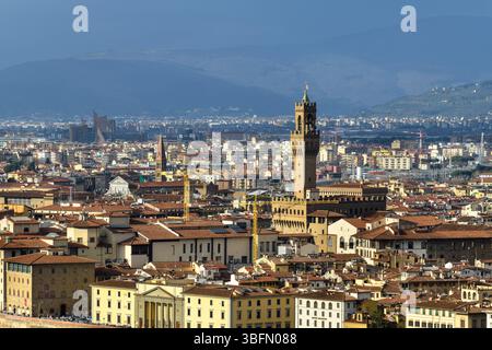 Panoramablick auf Florenz, Italien, mit Palazzo Vecchio, mittelalterlichen Stadtmauern und urbaner Landschaft unter einem dramatischen Himmel. Stockfoto