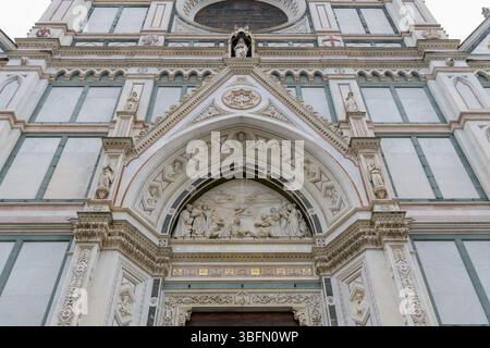 Zentrales Portal der Basilika Santa Croce in Florenz mit gotischem Marmorbogen und Lünettenrelief des Triumphes des Kreuzes von Giovanni Dupre, reich oder Stockfoto
